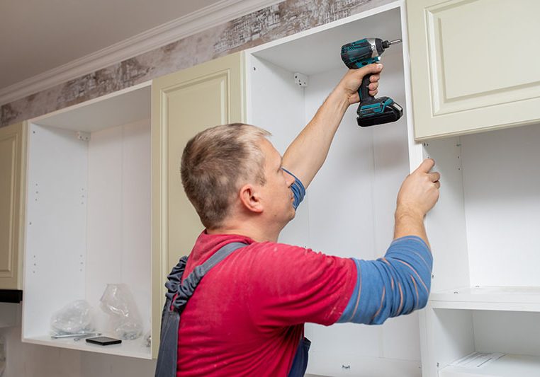 Craftsman kitchen carpenter at kitchen furniture set installation service work. Man during the work